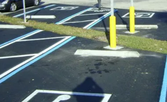 Striping machine painting bright white lines on new asphalt